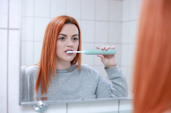鏡の前で歯みがきする女性